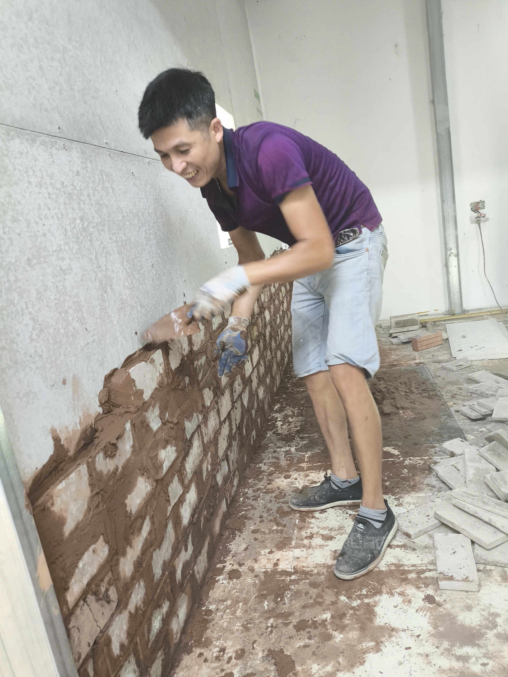 Thợ xây trát hoàn thiện tường phòng X-quang sử dụng gạch barite chống tia X